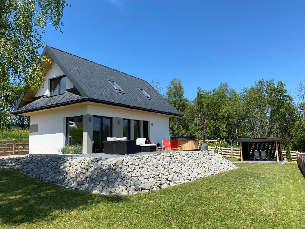 a house with a black roof and a gravel yard at Beskidzki Reset in Budzów