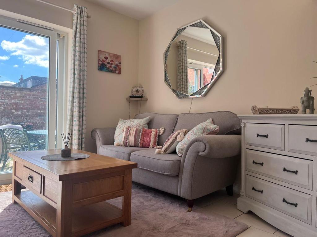 a living room with a couch and a mirror at Centrally Located Lincolnshire Home With Free Parking On Premises in Lincolnshire
