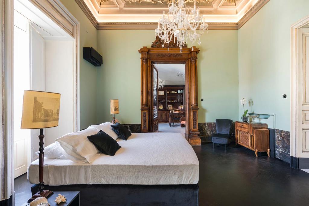 Schlafzimmer mit einem Bett und einem Kronleuchter in der Unterkunft DIMORA PATERNÒ DEL GRADO in Catania