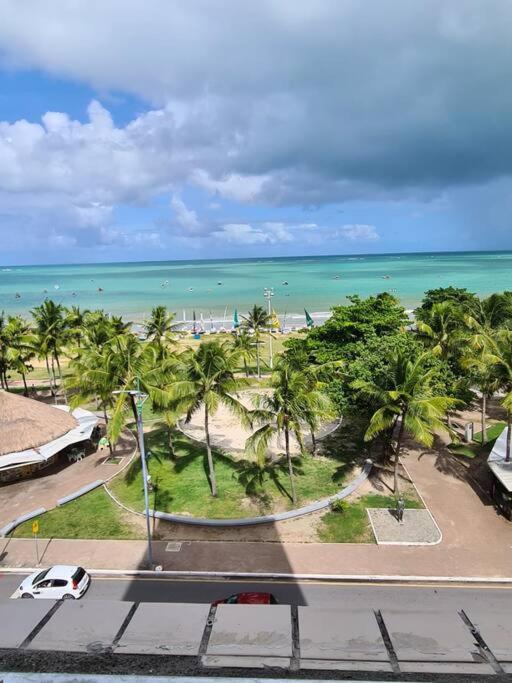 uma vista para uma praia com palmeiras e para o oceano em APARTAMENTO ENCANTADOR NA BEIRA-MAR DE MACEIÓ em Maceió