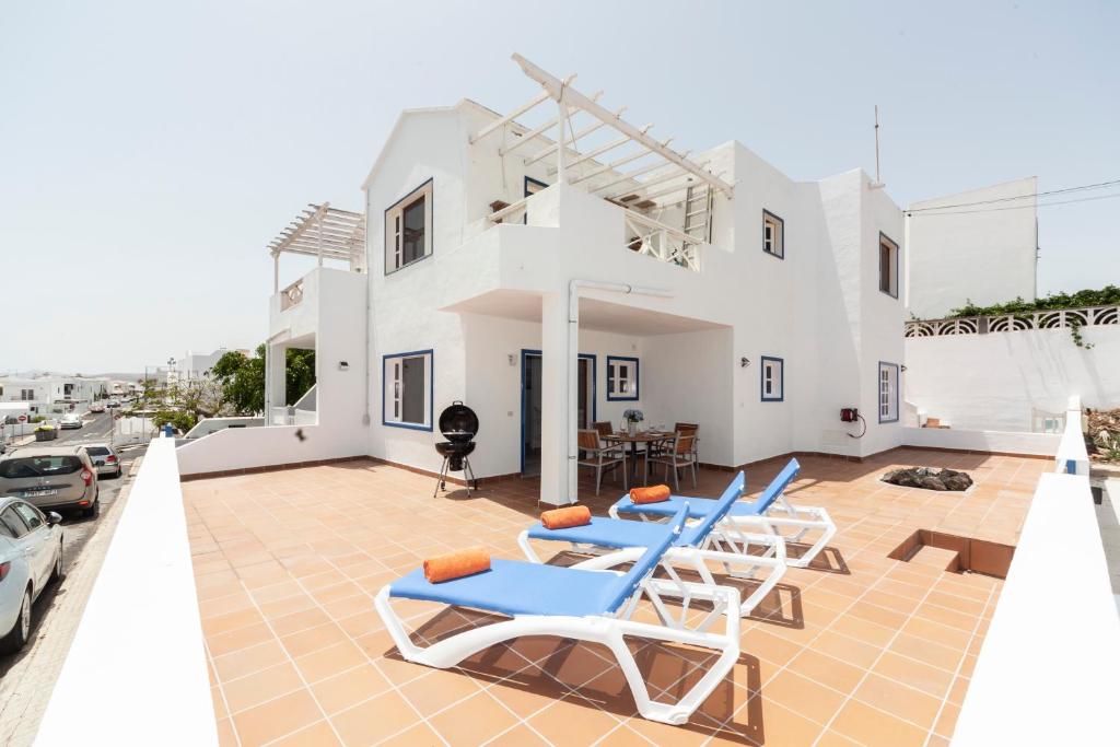 une villa avec une piscine et des chaises longues dans l'établissement Luxury Beach Fayna, à Playa Honda