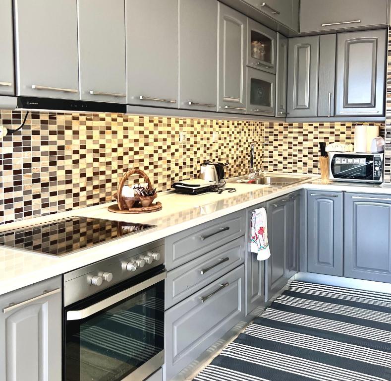 a kitchen with white cabinets and blue appliances at Villa Kastro Elassona in Elassona