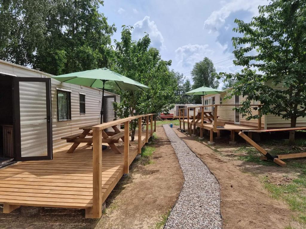 a row of lodges with wooden decks and umbrellas at Pod bocianim gniazdem in Węgorzewo