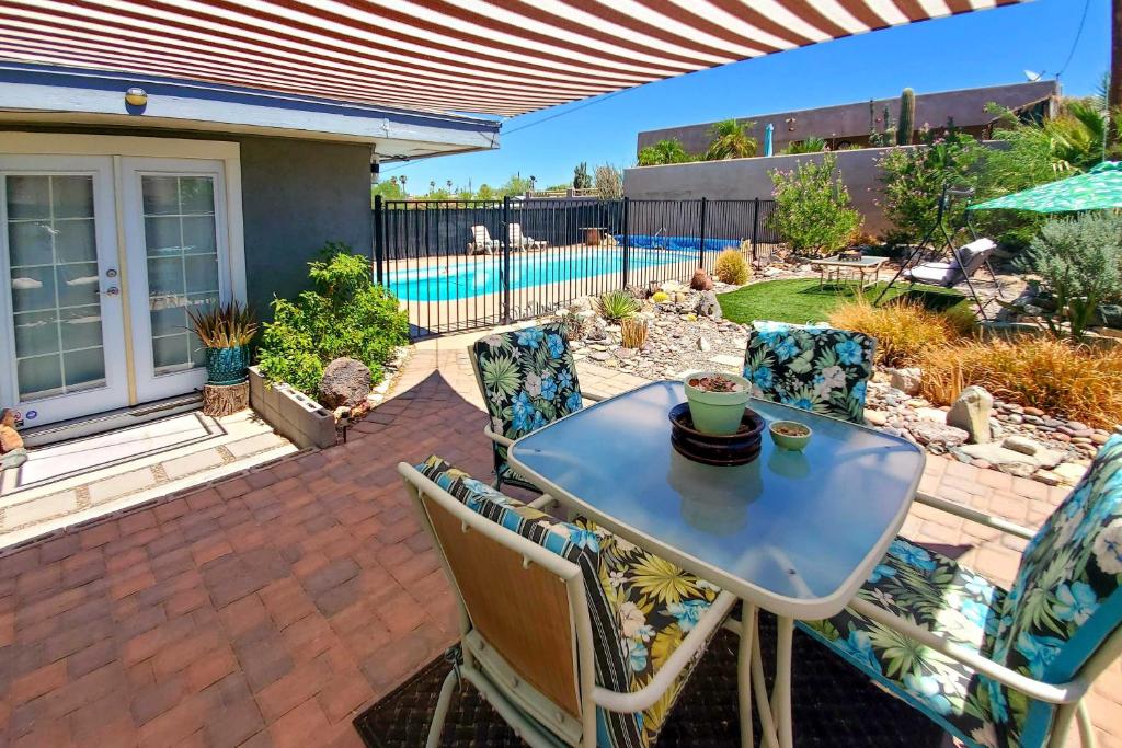 a patio with a table and chairs and a pool at 4 Mi to Beach Lake Havasu Apartment with Pool! in Lake Havasu City
