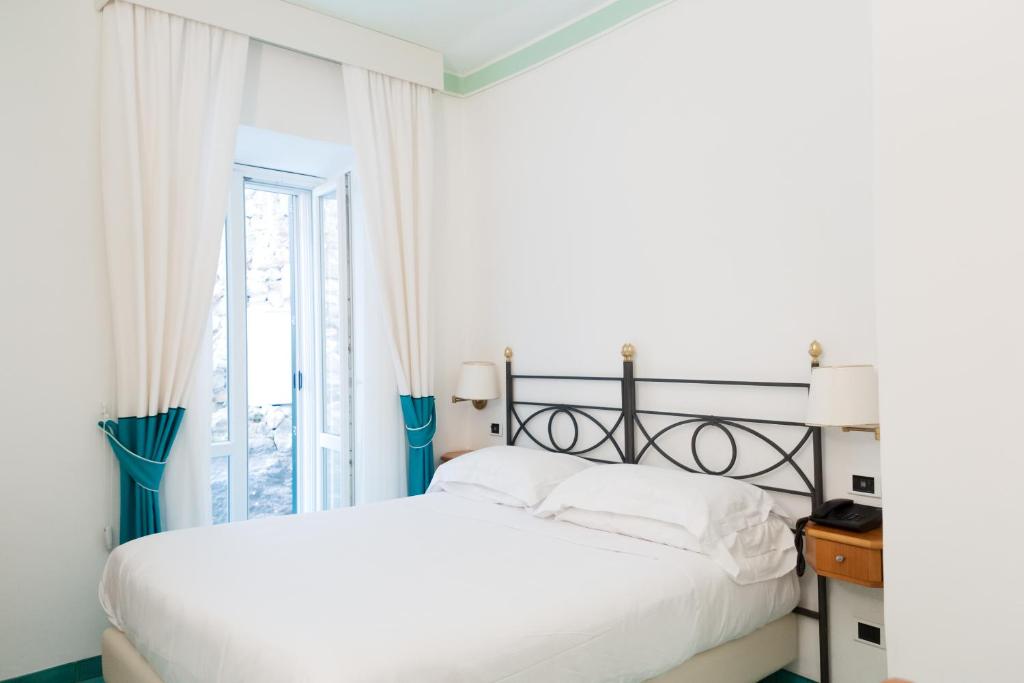 Postel nebo postele na pokoji v ubytování Grand Hotel Santa Domitilla