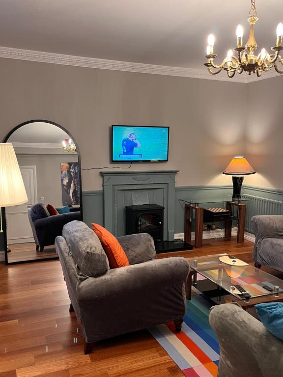 uma sala de estar com sofás e uma lareira com uma televisão em No10bridgestreet em Westport