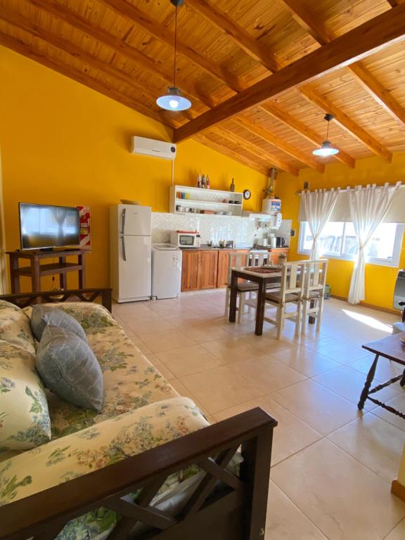 a living room with a couch and a kitchen at Departamento Diag Buenos Aires 55 in Capilla del Monte