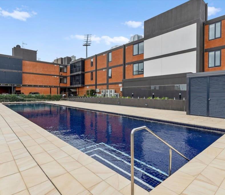 a swimming pool in front of a building at Luxury 3 bdm Spacious apt in the heart of Wagga in Wagga Wagga