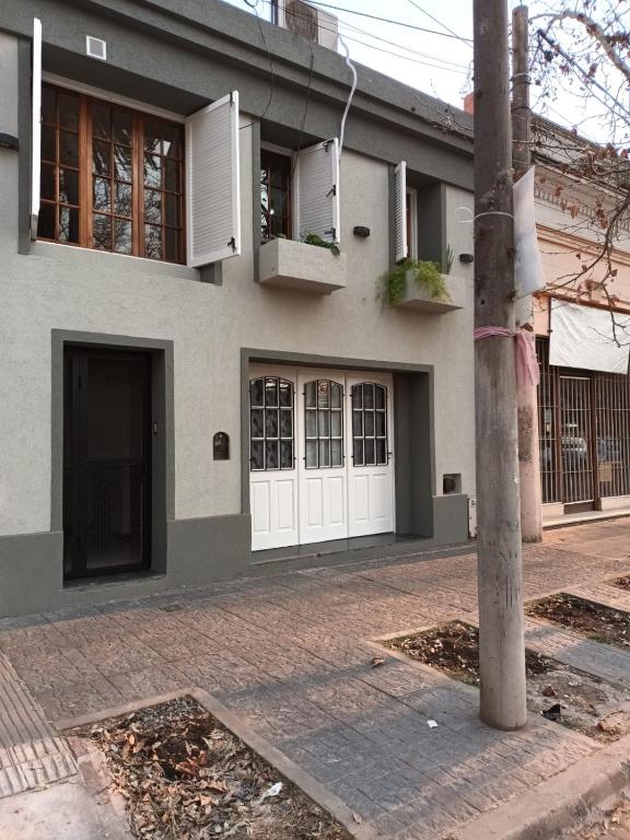 a house with white doors on a street at Casa céntrica premium in San Pedro