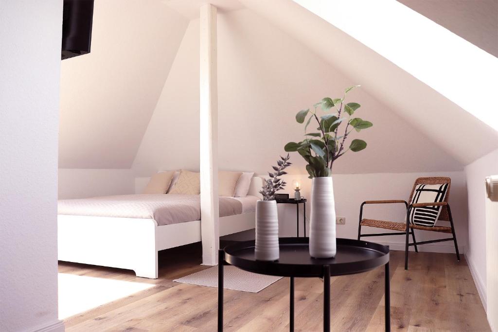 ein Schlafzimmer mit einem Bett und einem Tisch mit Vasen darauf in der Unterkunft Kostengünstige & charmante Ferienunterkunft ohne Küche und in Strandnähe - Ideal für Kurztrips oder 1-Nacht Aufenthalte in Scharbeutz