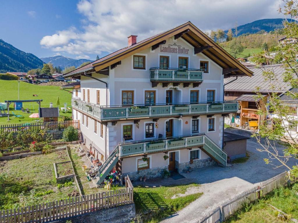 un gran edificio blanco con balcones y una valla en Landhaus Hotter 12 en Neukirchen am Großvenediger