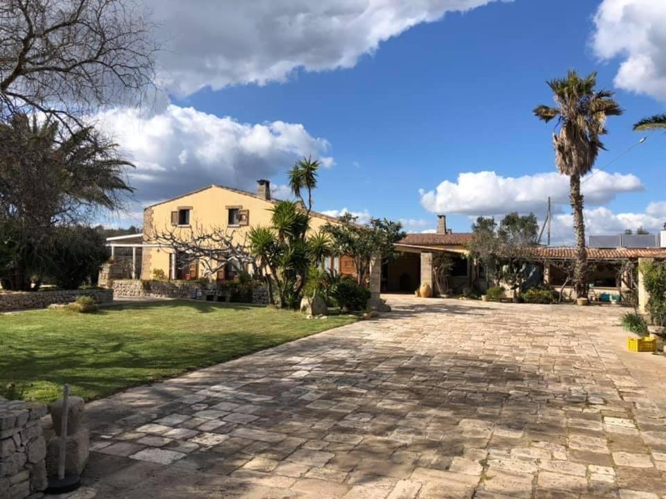 une maison avec des palmiers et une allée en pierre dans l'établissement Agriturismo Masseria Alcorico, à Gagliano del Capo