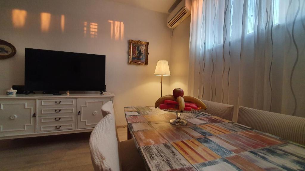 ein Wohnzimmer mit einem Tisch und einem TV in der Unterkunft Apartment Factory in Dubrovnik