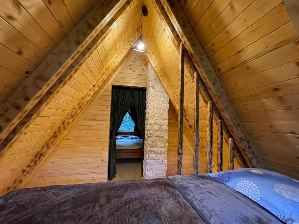 Cette chambre comprend un lit dans une cabane en bois. dans l'établissement Rajska suma, à Žabljak