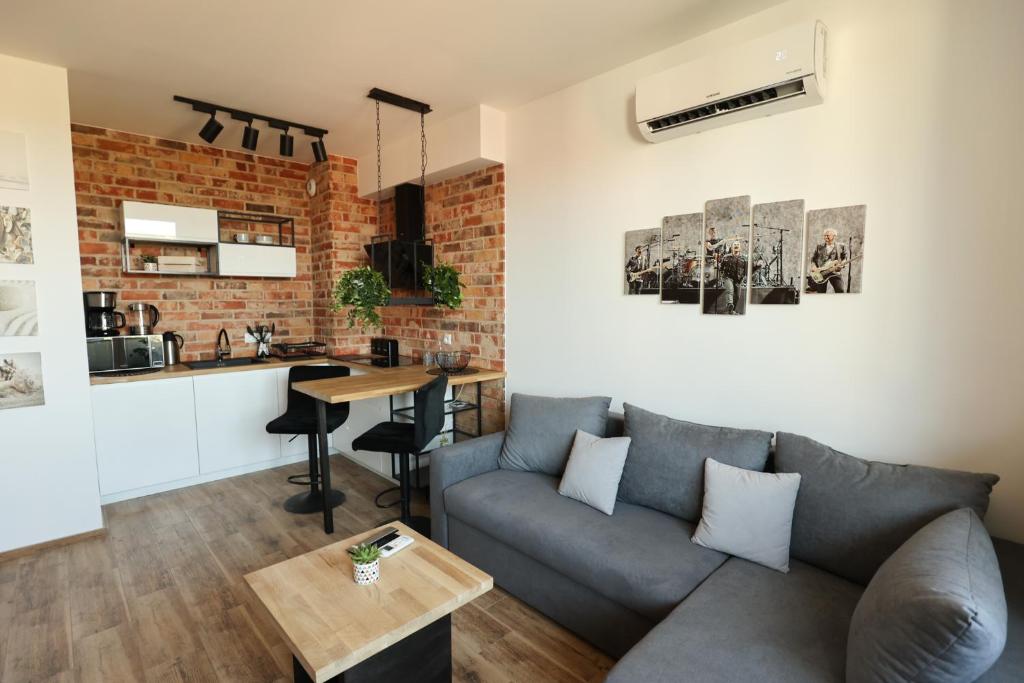 a living room with a couch and a kitchen at Nobel 55 Apartament in Władysławowo