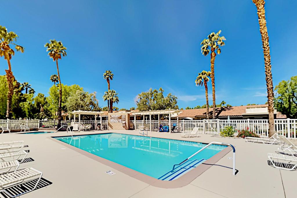 una piscina con sillas y palmeras en Palm Desert Resorter 42-04 Permit# STR2023-0238, en Palm Desert