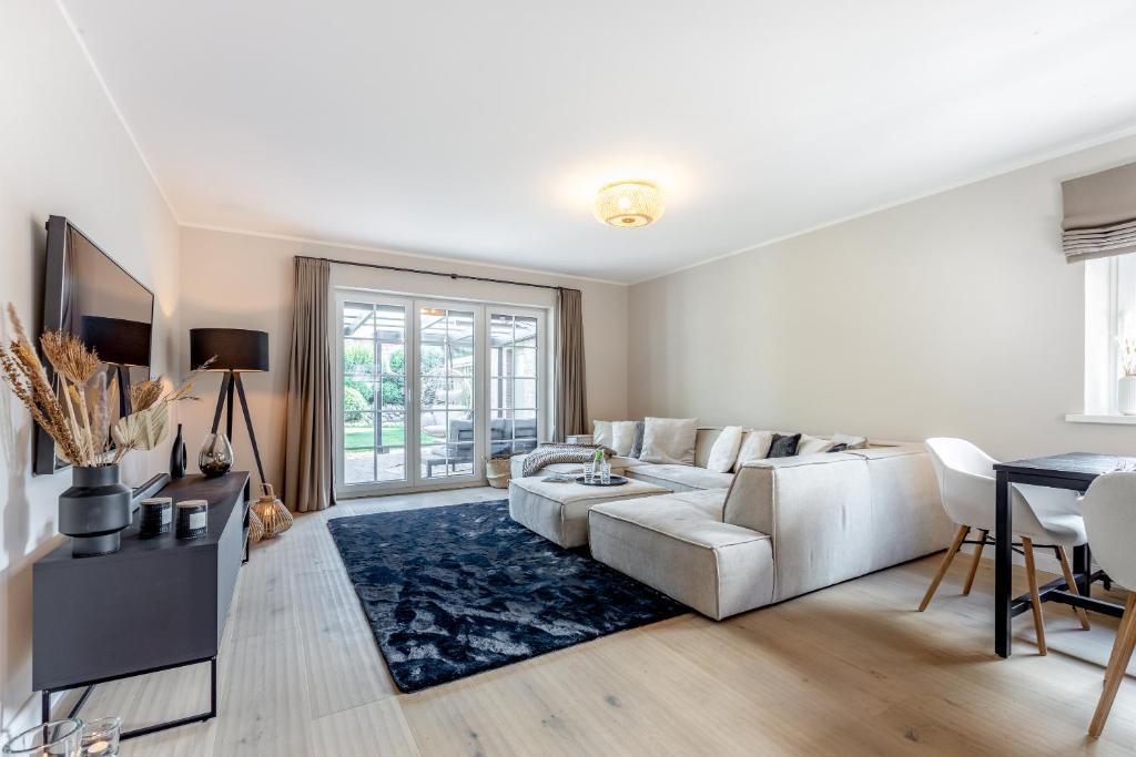un soggiorno con divano bianco e tappeto blu di Dünen Lodge a Westerland