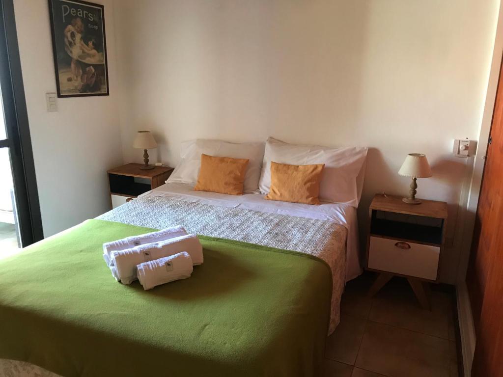 1 dormitorio con 1 cama y 2 mesas con lámparas en DEPTO EN VILLA GRAL BELGRANO en Villa General Belgrano
