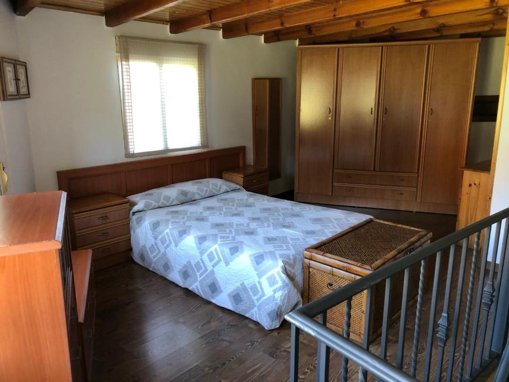 una camera con letto e armadio in legno di Casa Pedragude. Turismo rural. a Pantón