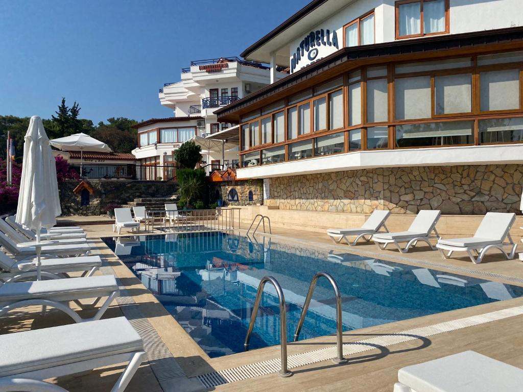 a hotel with a swimming pool next to a building at NATURELLA APART HOTEL in Kemer
