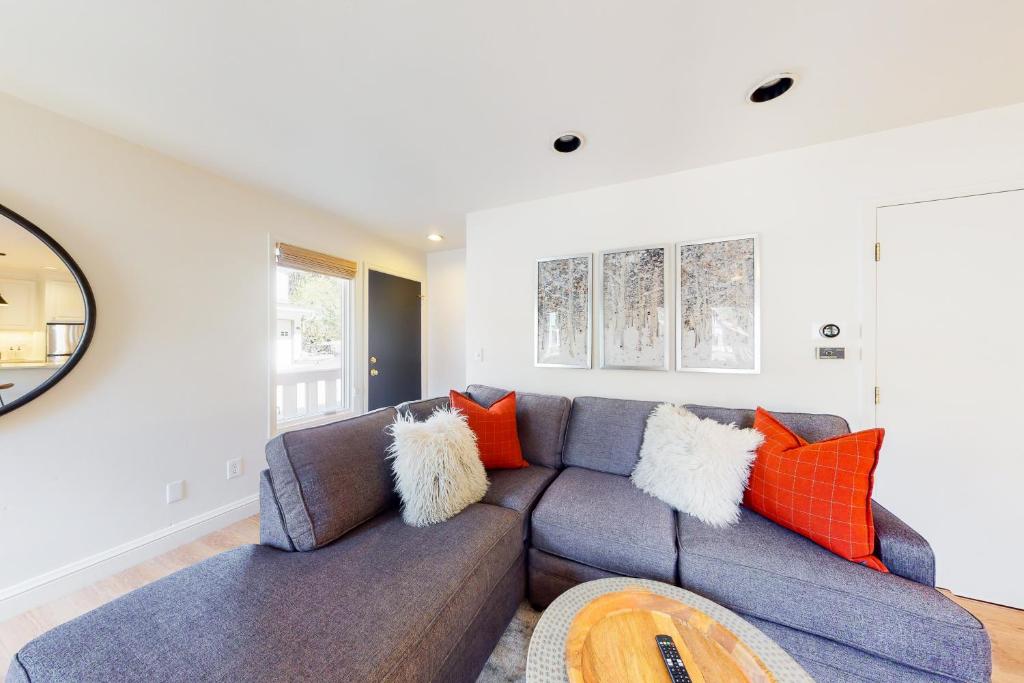 uma sala de estar com um sofá azul e almofadas laranja em East Vail Escape em Vail