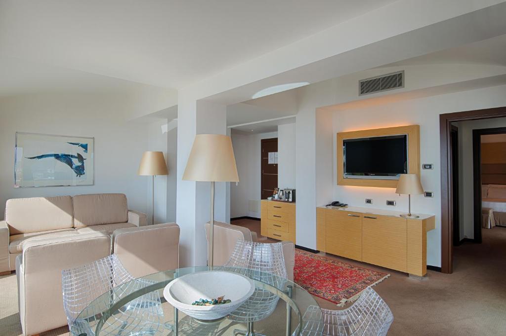 sala de estar con mesa de cristal y sofá en GH Palazzo Suite & SPA, en Livorno
