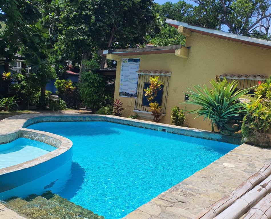 a swimming pool in front of a house at Hostal Nova Colonial in Puerto Colombia