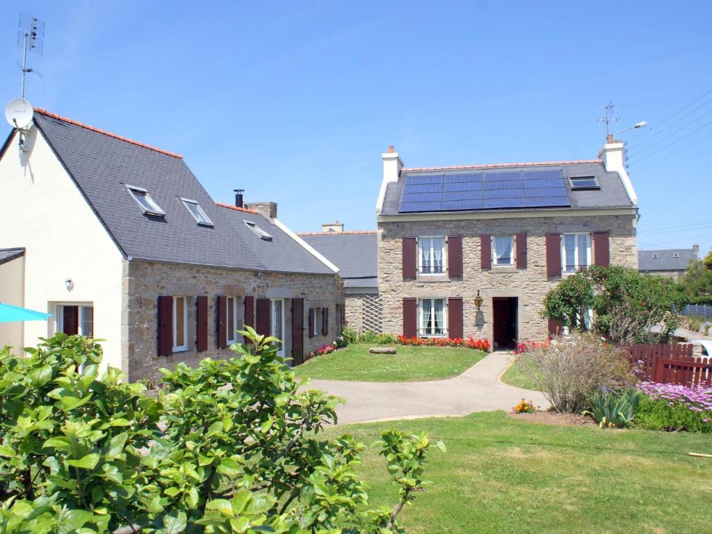 una casa con paneles solares en el techo en L-shaped Breto stone house with sauna, Lampaul-Plouarzel en Lampaul-Plouarzel