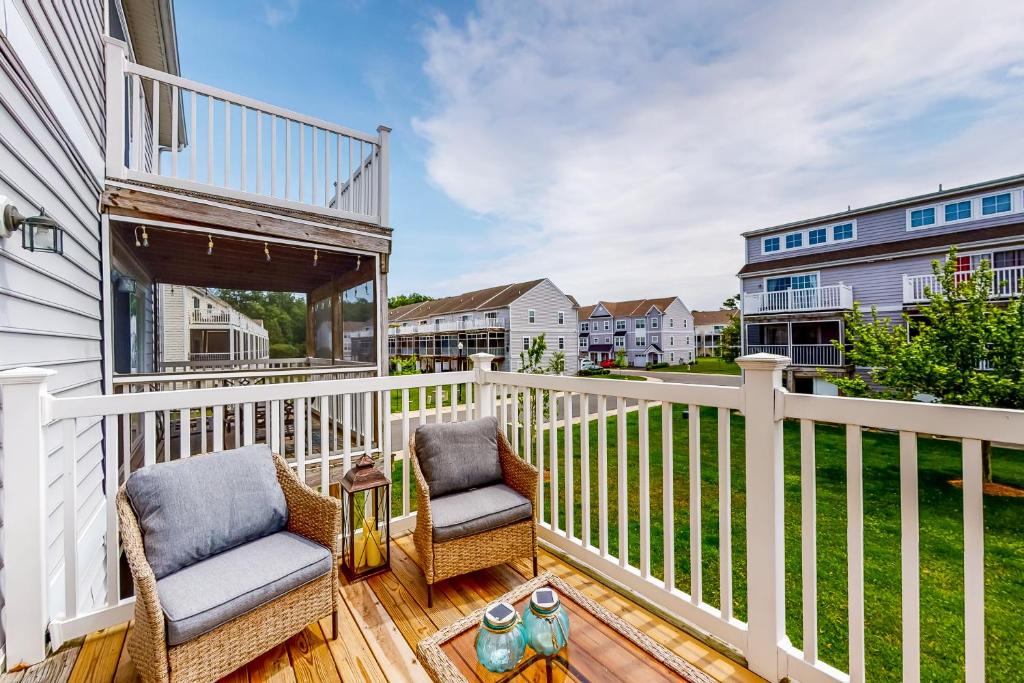 een balkon met 2 stoelen en een tafel op een huis bij Rehoboth Crossing - 19797 Keystone Dr, Unit 141 in Rehoboth Beach