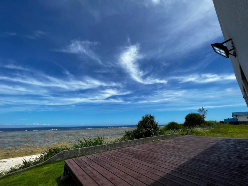a view of the beach from the porch of a house at ゴールデンマイルヴィラ in Amami