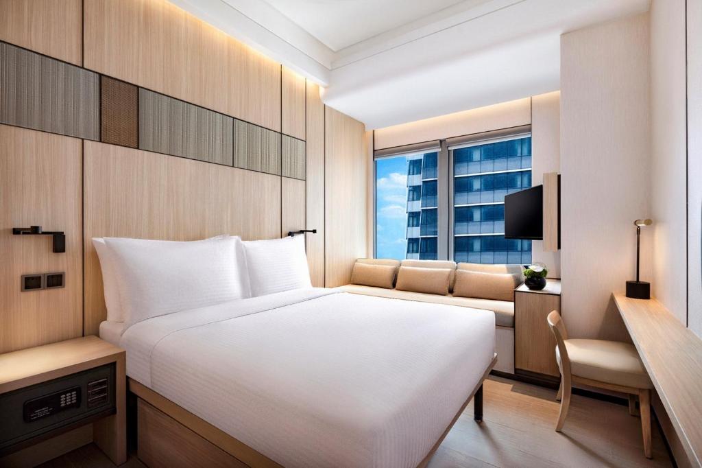 a bedroom with a large white bed and a couch at Harbour Plaza Metropolitan Shanghai in Shanghai