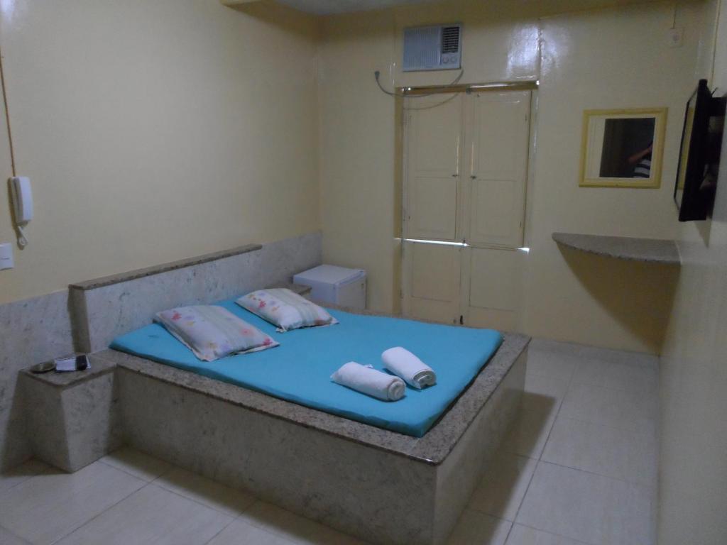 Bett im Bad mit Dusche und Handtüchern in der Unterkunft Hotel Avenida in Vitória