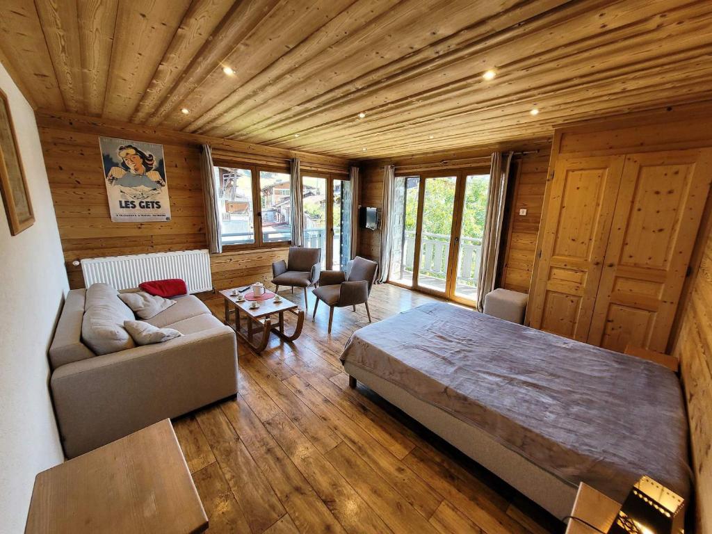 - une chambre avec un grand lit et un canapé dans l'établissement Appartement cosy, 3 balcons, plein centre, proche pistes - idéal 5-6 pers. - FR-1-598-101, aux Gets