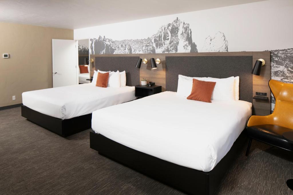 a hotel room with two beds and a chair at Waypoint Hotel in Bend