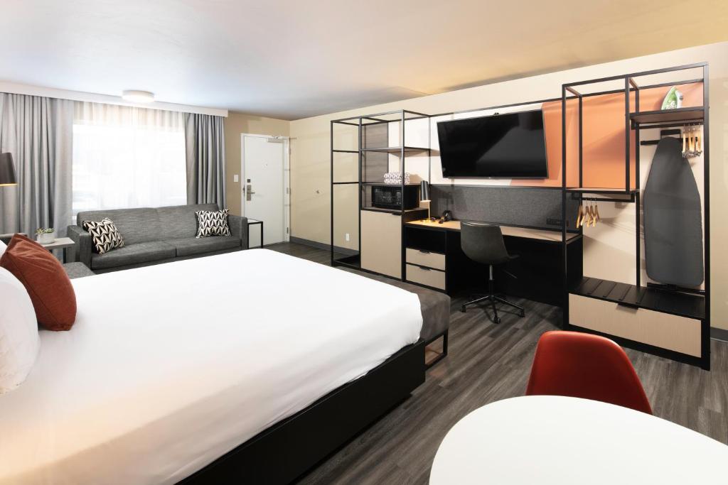 a hotel room with a bed and a flat screen tv at Waypoint Hotel in Bend