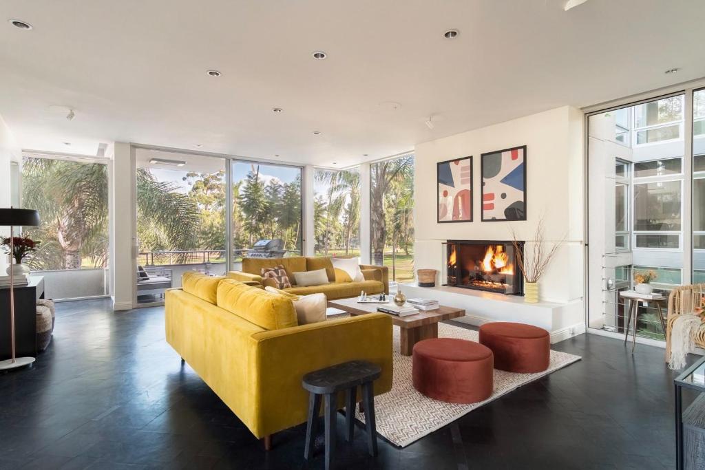 a living room with a yellow couch and a fireplace at Balboa I by AvantStay - Stylish Condo Balboa Park Adjacent w Views in San Diego