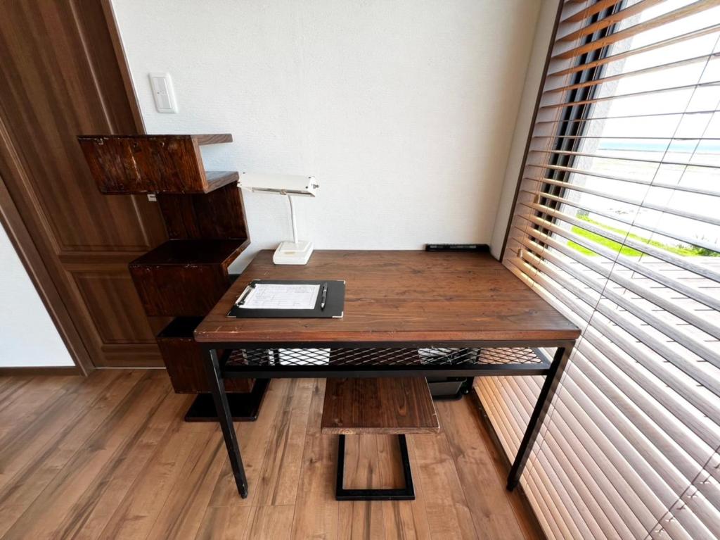 a desk in a room with a window at ゴールデンマイルヴィラ in Amami