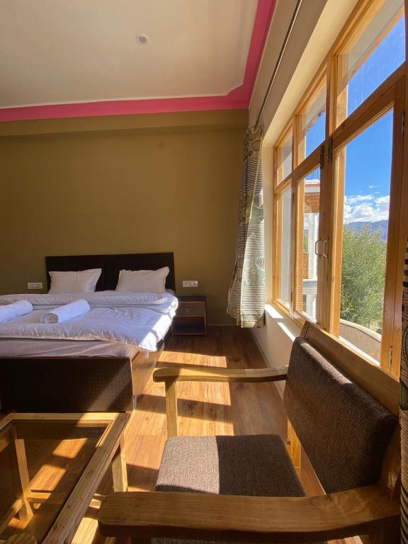 una camera da letto con due letti e una finestra di Rabyang Guest House and Homestay a Leh