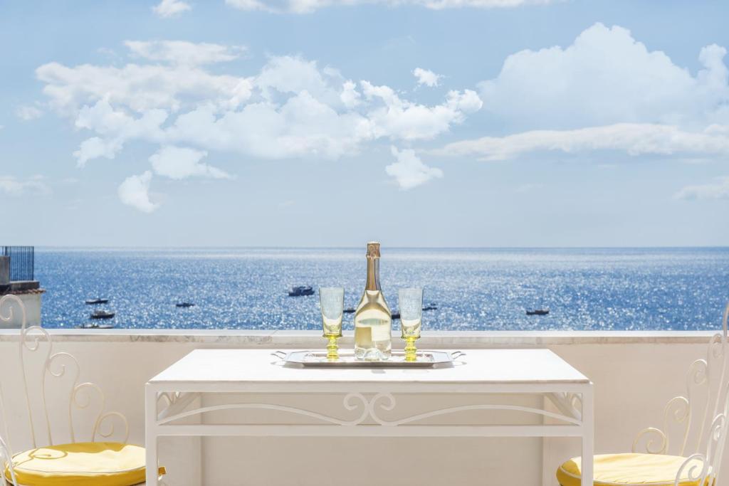 a white table with a bottle of wine and glasses on it at Villa Flavio Gioia in Positano