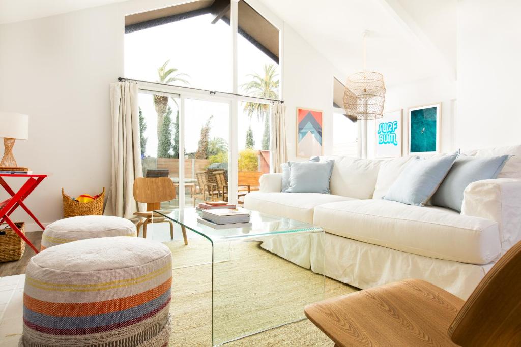 een woonkamer met een witte bank en een glazen tafel bij Hamilton I by AvantStay Beach House Rooftop Deck Newly Renovated Bungalow in San Diego