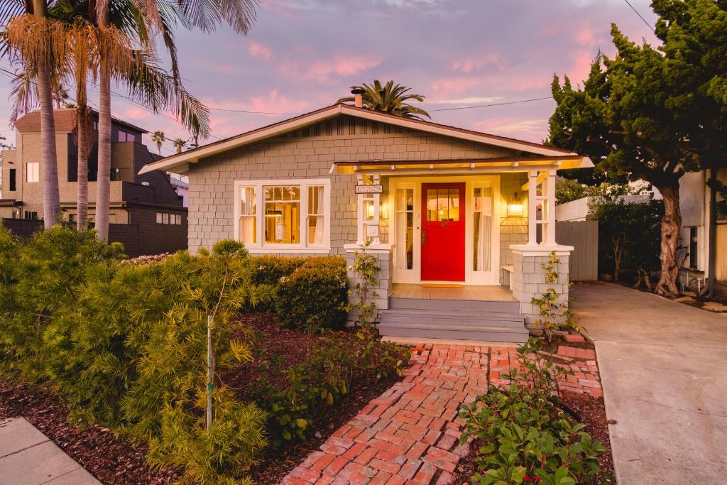 a house with a red door on a brick driveway at Topaz By AvantStay Adorable Cottage Walking Distance to Beach w Large Patio in San Diego