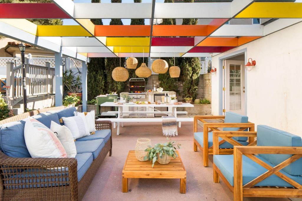un patio con un sofá azul, sillas y una mesa en Kokomo by AvantStay Bayside Getaway w Fire Pit Large Outdoor Patio en San Diego