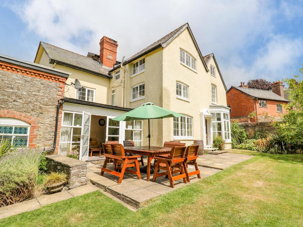 a patio with a table with chairs and an umbrella at The Laurels in Bishops Castle