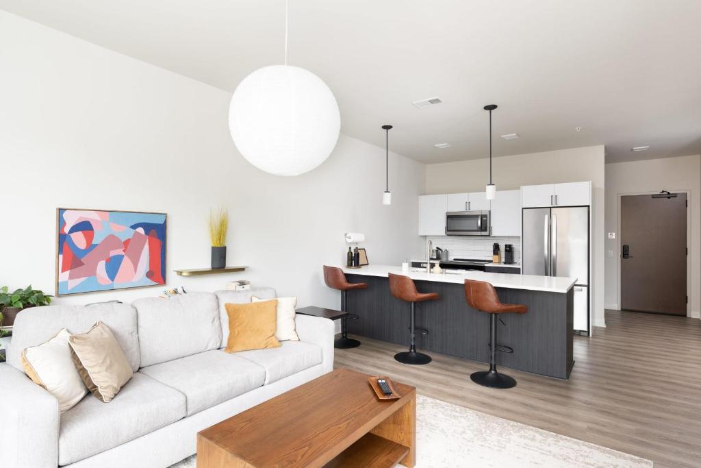 Il comprend un salon avec un canapé blanc et une cuisine. dans l'établissement Flexhome Brady District 1BR Apt E3 - READ INFO, à Milwaukee