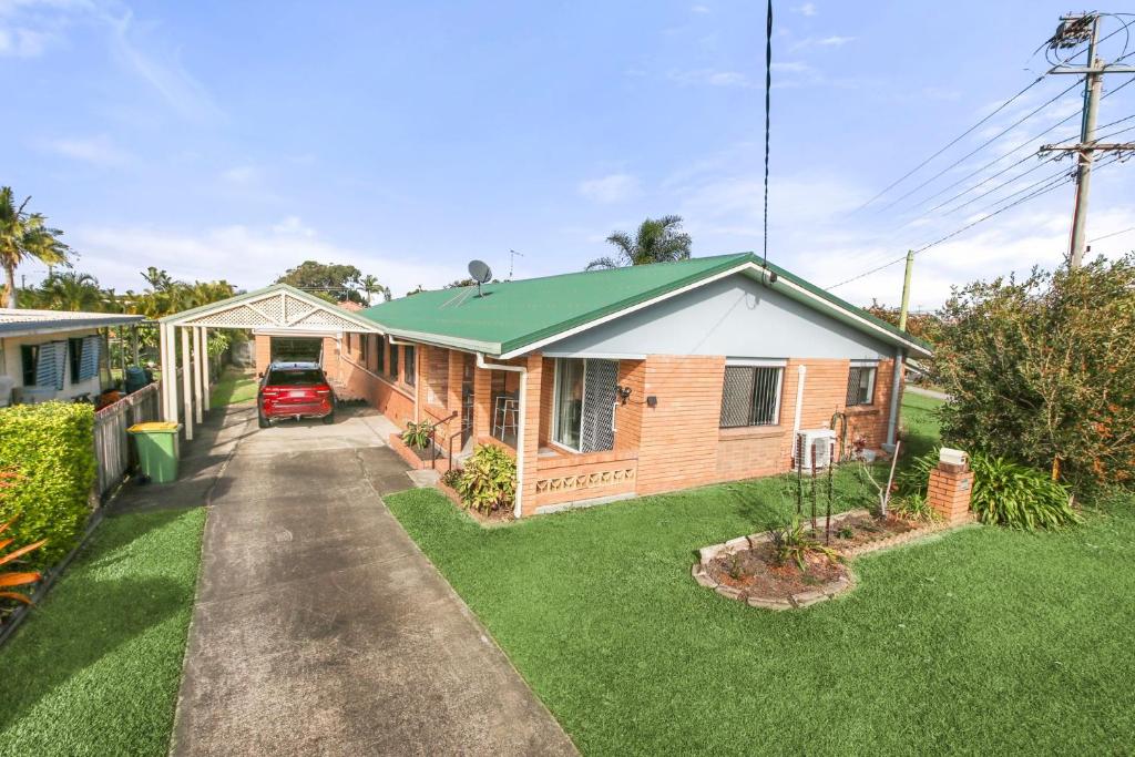 a house with a green roof and a driveway at Bell Street 36 Dicky Beach in Caloundra
