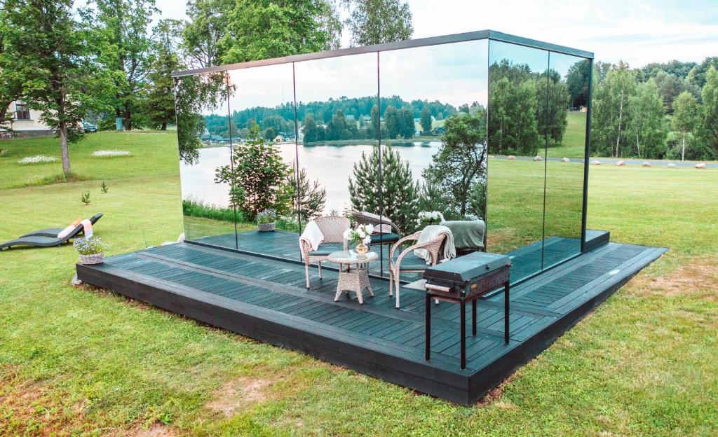 a glass house with a table and chairs on a deck at ÖÖD Hötels Rõuge in Rouge