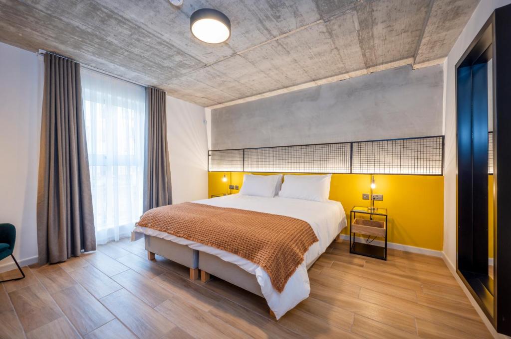 a bedroom with a large bed and a yellow wall at Fort40 Guest House in Sliema