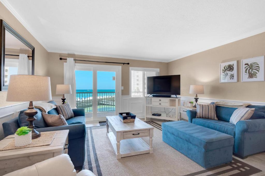 a living room with blue couches and a television at Holiday Surf and Racquet Club 319 in Destin