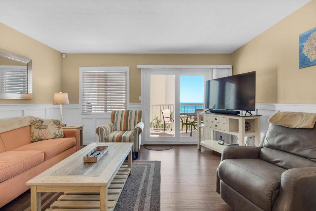 a living room with a couch and a flat screen tv at Holiday Surf and Racquet Club 412 in Destin