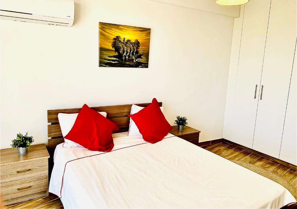 a bedroom with a bed with red pillows at BALI SUITES 303 in Larnaka